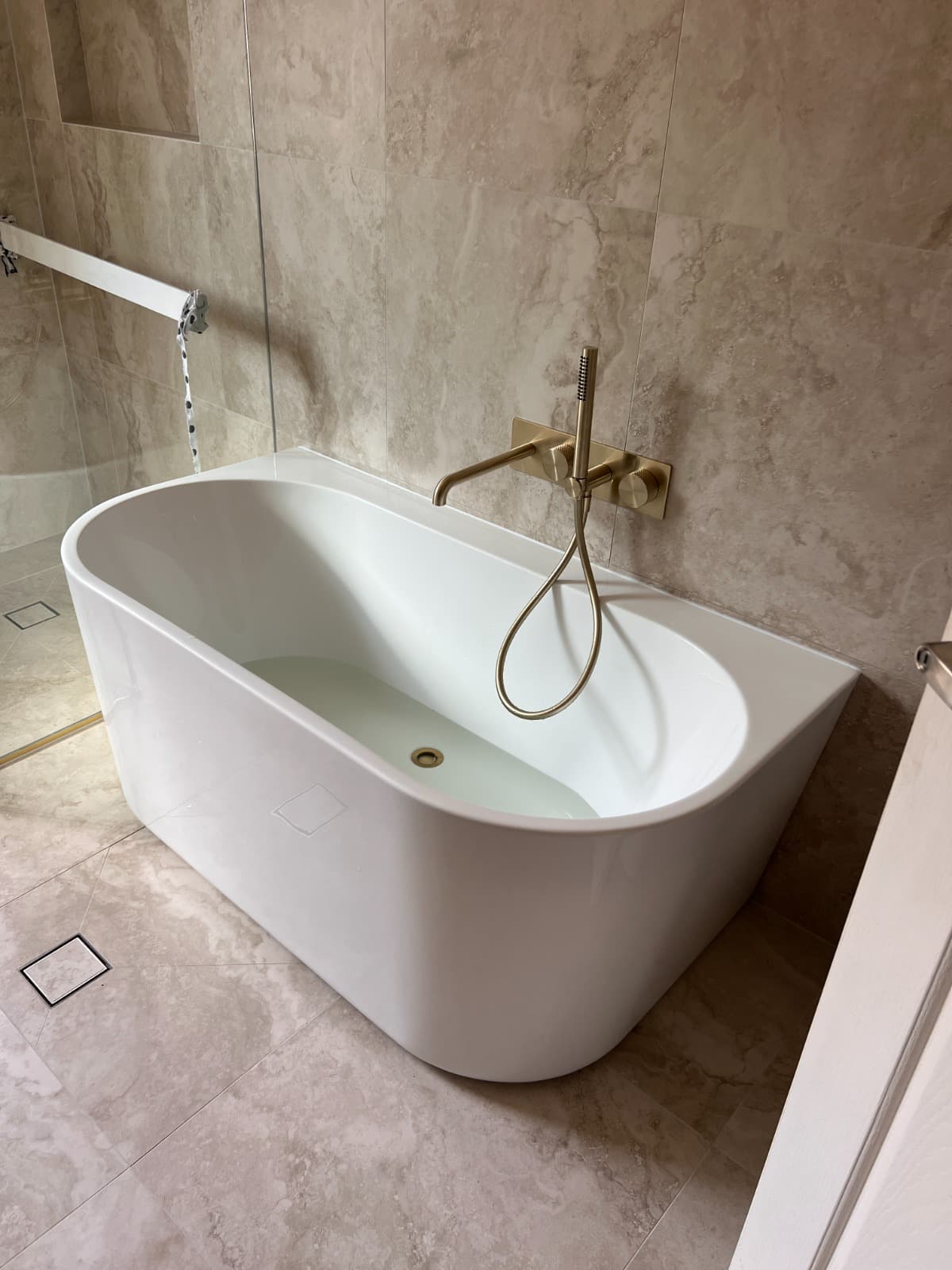 Installed bath mixer and bathtub plumbing